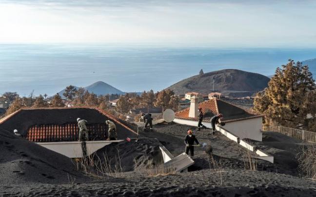 Militares retiran ceniza del tejado de una casa, en la zona de exclusión próxima al volcán de Cumbre Vieja. Militares retiran ceniza del tejado de una casa, en la zona de exclusión próxima al volcán de Cumbre Vieja.