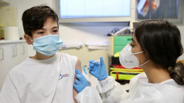 Una sanitaria vacuna contra el Covid-19 a un niño.