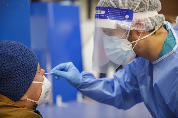 Un sanitario realiza una prueba PCR.