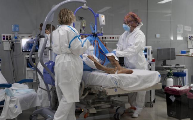 Varios sanitarios alrededor de un paciente ingresado en la UCI.