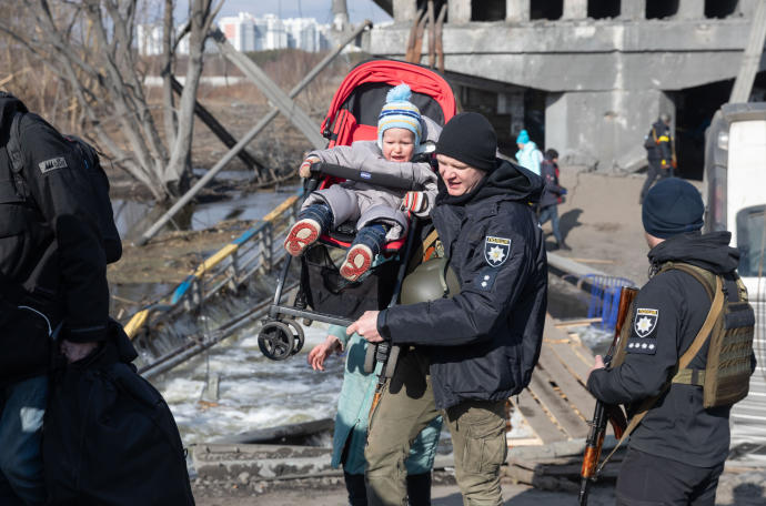Un militar lleva a un niño durante la evacuación de civiles en Irpin.
