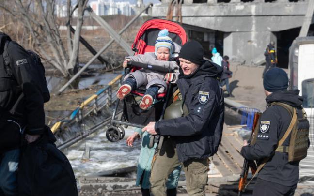 Un militar lleva a un niño durante la evacuación de civiles en Irpin.