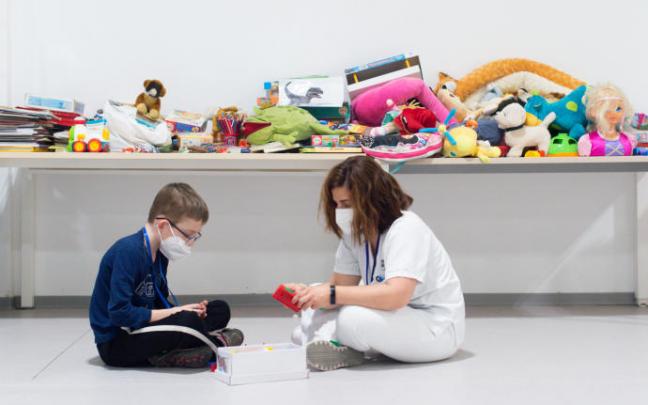 Una trabajadora sanitaria juega con un niño procedente de Ucrania.