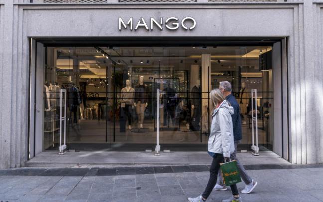 Dos personas pasan por delante de una tienda Mango. Dos personas pasan por delante de una tienda Mango.
