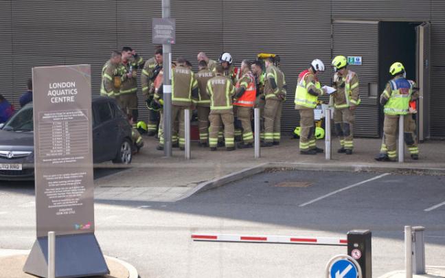 Servicios de emergencia se cerca del Centro Acuático del Parque Olímpico Queen Elizabeth.