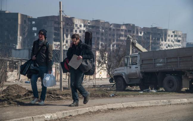 Dos ucranianos intentan salir de la ciudad de Mariúpol.