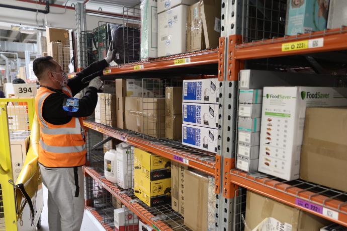 Un trabajador prepara varios pedidos en una empresa de distribución.