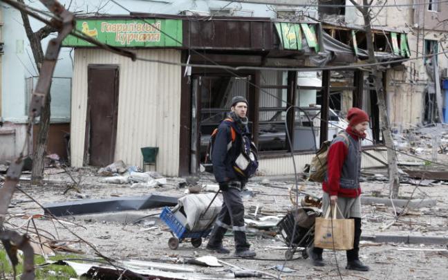 Dos personas caminan por las calles de Mariúpol.
