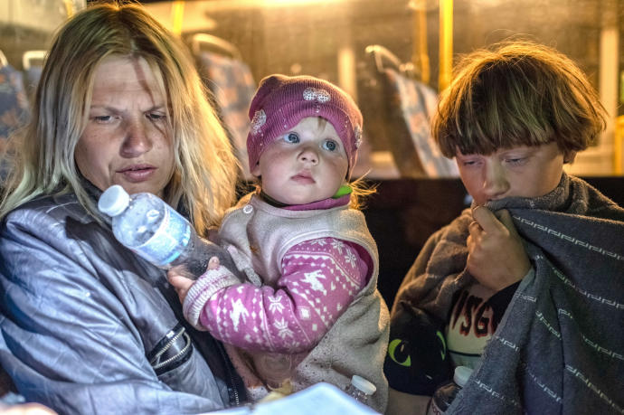 Una madre con sus hijos tras ser evacuados de Mariupol a Zaporizhia.