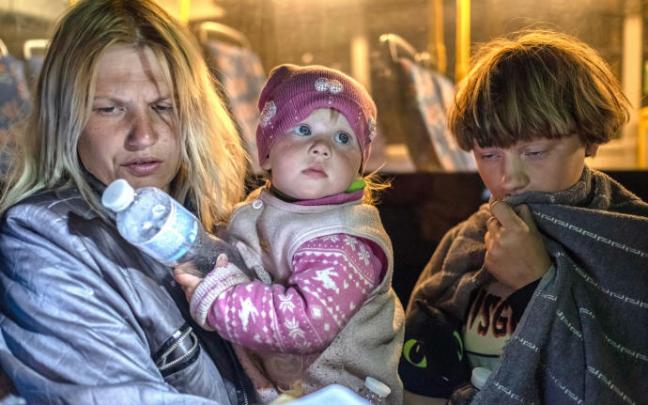 Una madre con sus hijos tras ser evacuados de Mariupol a Zaporizhia.