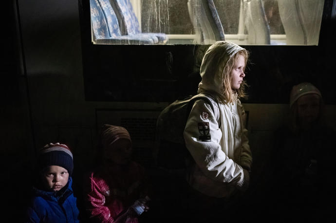 Una niña y sus hermanos viajan de Mariupol a Zaporizhia en una evacuación realizada por Cruz Roja.