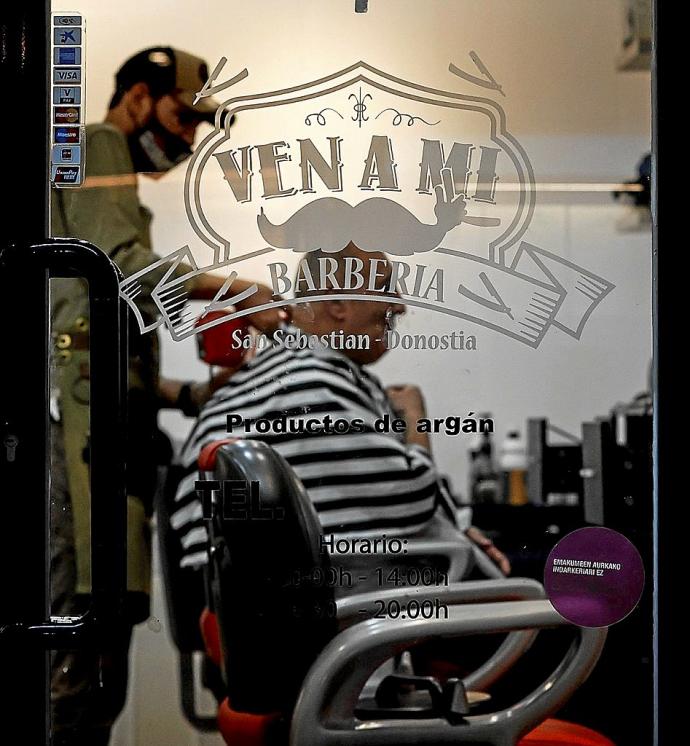 Un peluquero atiende a un cliente, ayer en Donostia. Foto: Efe