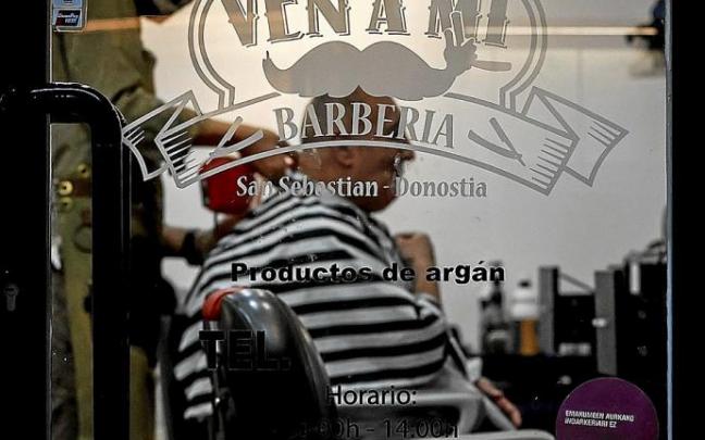 Un peluquero atiende a un cliente, ayer en Donostia. Foto: Efe Un peluquero atiende a un cliente, ayer en Donostia. Foto: Efe