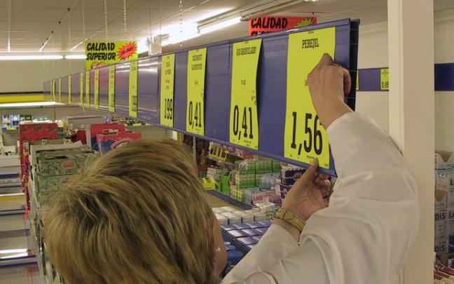 Una dependienta coloca los precios de los productos en su comercio.