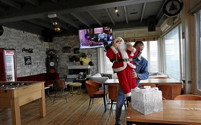 El encargado de un local retira toda la decoración navideña tras conocer que quedan prohibidas las celebraciones de Nochevieja y Reyes. Foto: Pablo Viñas