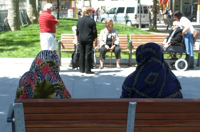 Varias personas descansan en un parque.