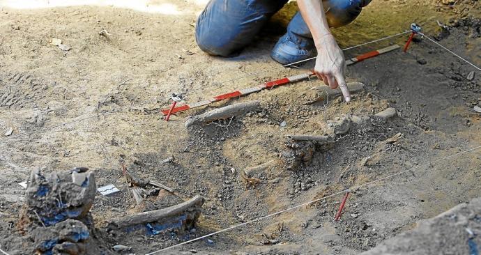 Un operario señala unos restos humanos durante la exhumación de un gudari en una fosa de Mendata.