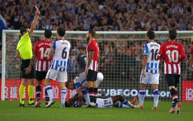El colegiado Juan Martínez Munuera muestra la cartulina roja a Iñigo Martínez después de que el central del Athletic viera la segunda amarilla por dar un manotazo a Isak.