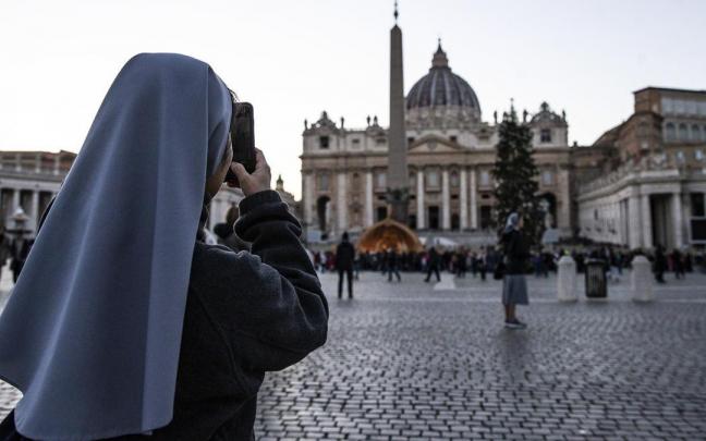 Una monja fotografía la basílica de San Pedro en el Vaticano.