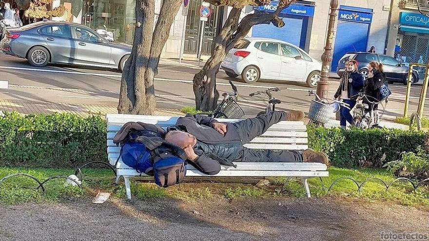 Una persona sin hogar tumbada en un banco en Donostia.