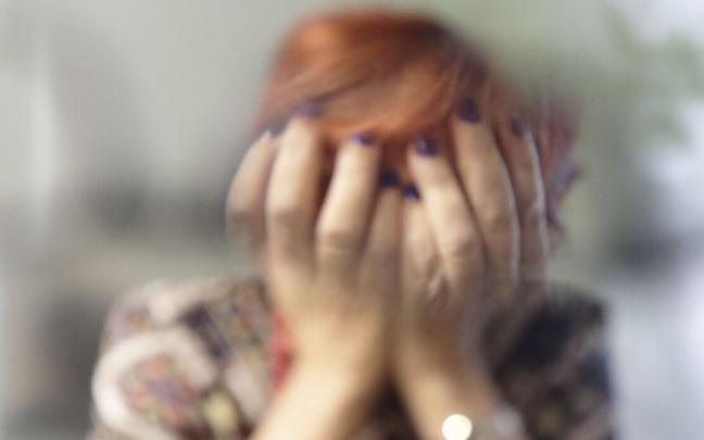 Imagen de archivo de una persona tapándose el rostro con sus manos.
