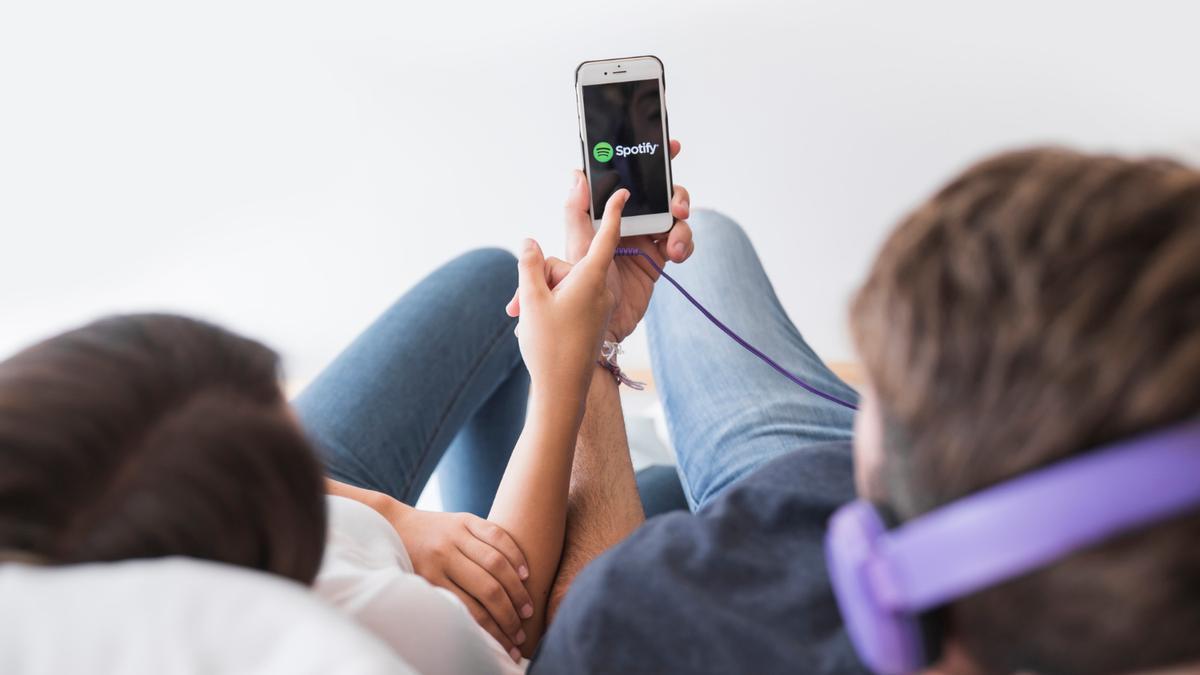Una pareja se prepara para abrir la aplicación de música y compartir escuchar la misma 'playlist'
