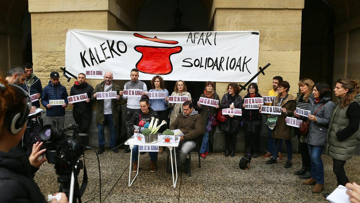 Varios voluntarios de Kaleko afari solidarioak, en la rueda de prensa que han ofrecido hoy en la Parte Vieja.