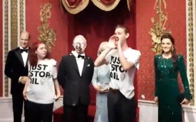 Momento en el que los dos ecologistas lanzan la tarta contra la figura de cera de Carlos III.