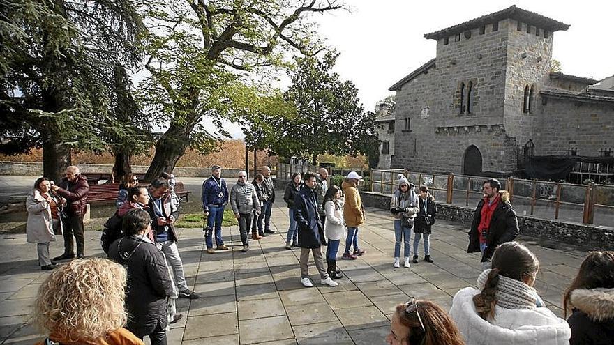 Un grupo de unas 20 personas escucha atentamente al guía en una visita a la ciudad.