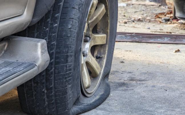 El neumático de la rueda trasera de un coche, destrozado tras sufrir un reventón. El neumático de la rueda trasera de un coche, destrozado tras sufrir un reventón.
