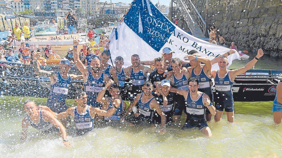 Los remeros de Urdaibai celebran, con la bandera en sus manos, el triunfo en la rampa del muelle donostiarra.