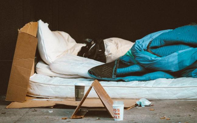 Una persona sin hogar duerme en la calle. Una persona sin hogar duerme en la calle.