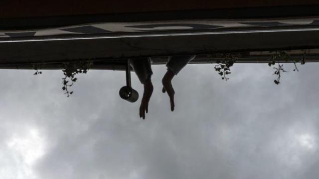 Vecinos realizando intercambios entre balcones de Pamplona mediante la teoría de las cuerdas durante el confinamiento.