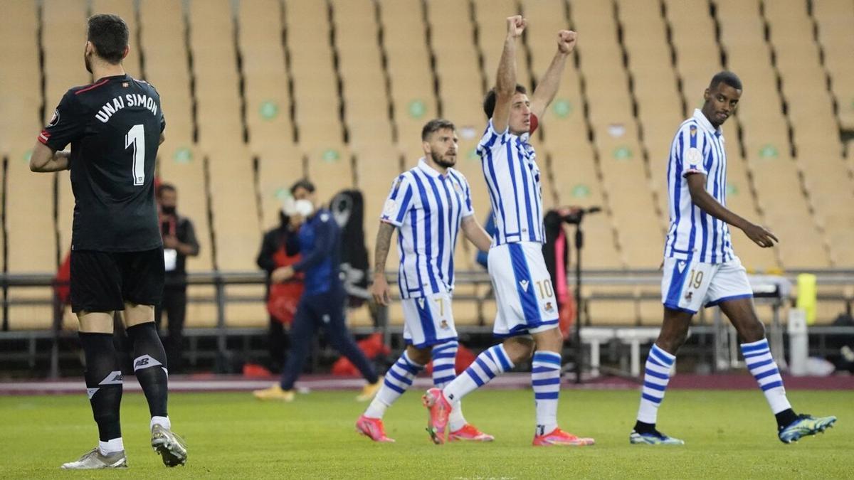 Oyarzabal celebra su gol con los brazos en alto, en presencia del meta rojiblanco Unai Simón