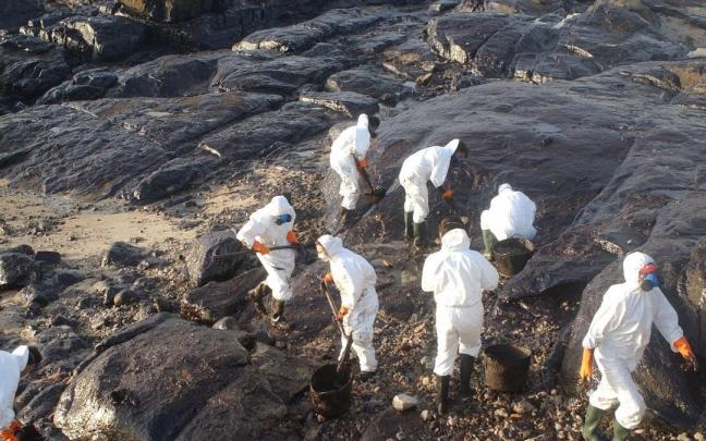 Los voluntarios limpian la costa gallega tras el vertido del Prestige.