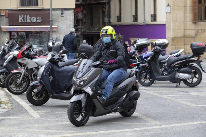 Una persona aparca su moto.