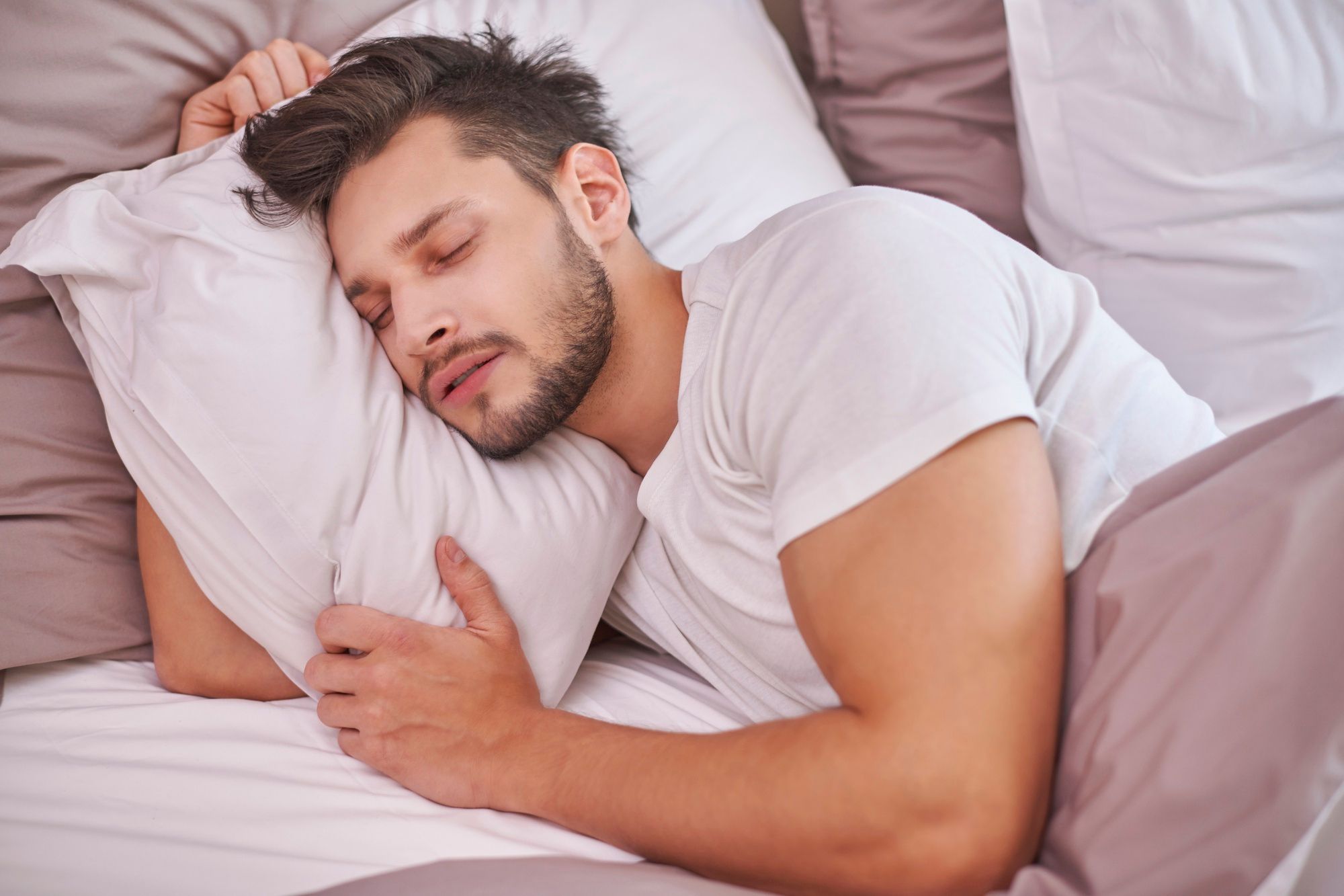 Un hombre duerme plácidamente en la cama.
