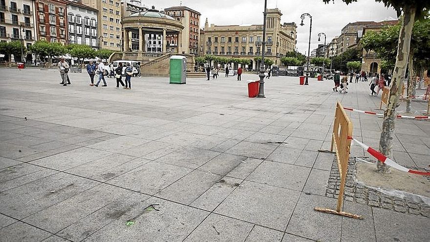 Marcas en el suelo de los bancos retirados en la plaza.