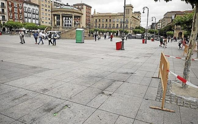 Marcas en el suelo de los bancos retirados en la plaza.