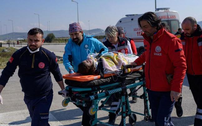 Efectivos de emergencias trasladan a una superviviente rescatada en Kahramanmaras.