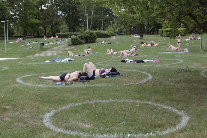 Varios usuarios toman el sol en las piscinas de Mendizorrotza.