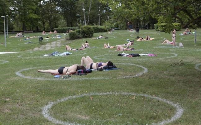 Varios usuarios toman el sol en las piscinas de Mendizorrotza.