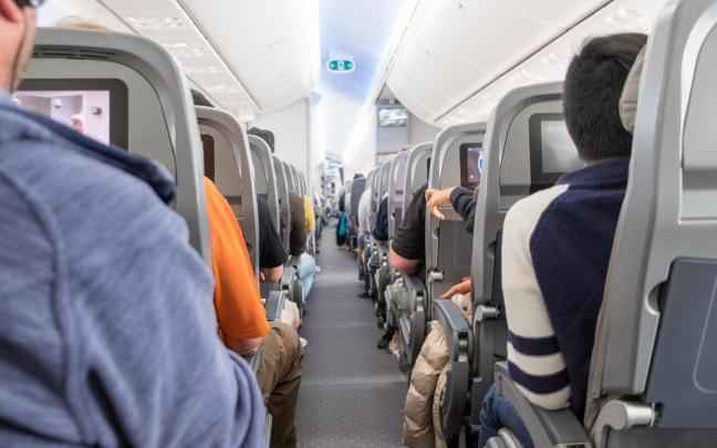 Pasajeros ocupan sus asientos en la cabina de un avión. Pasajeros ocupan sus asientos en la cabina de un avión.