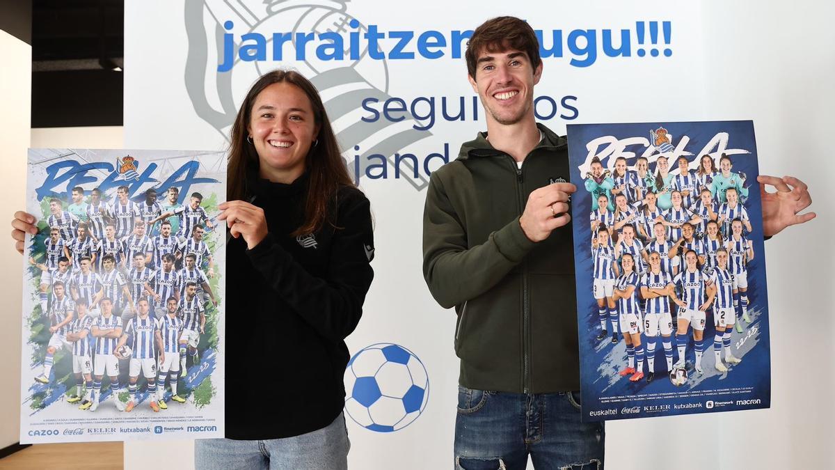 Amaiur Sarriegi y Aritz Elustondo, con los p&oacute;sters del equipo masculino y del conjunto femenino de la Real.