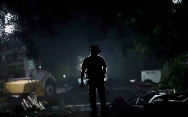 Un trabajador camina en la zona donde se encuentran mineros atrapados.
