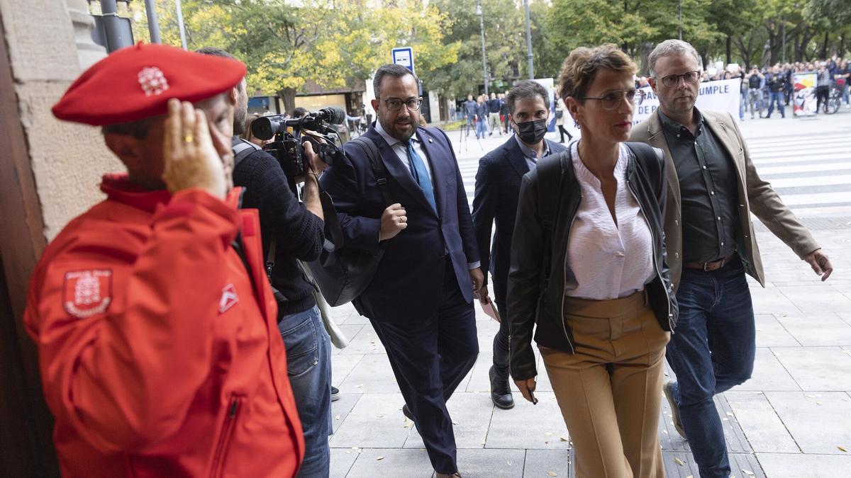 Un agente de Policía Foral saluda a Chivite y a miembros del Gobierno de Navarra al acceder al Parlamento.