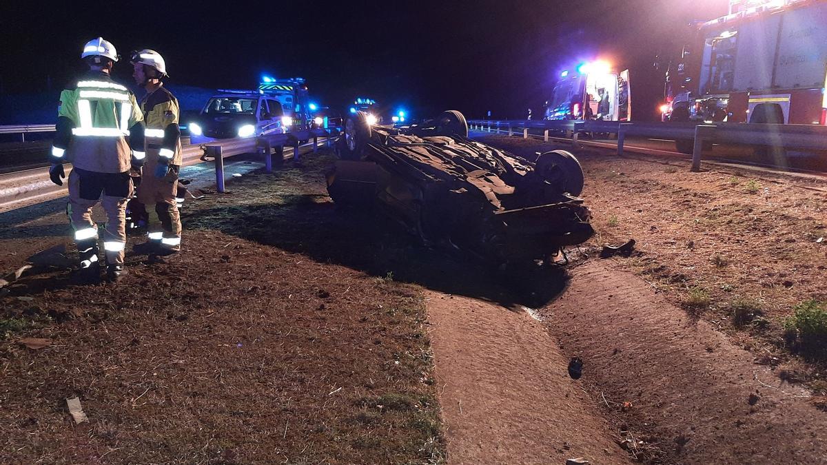 Coche volcado en la mediana