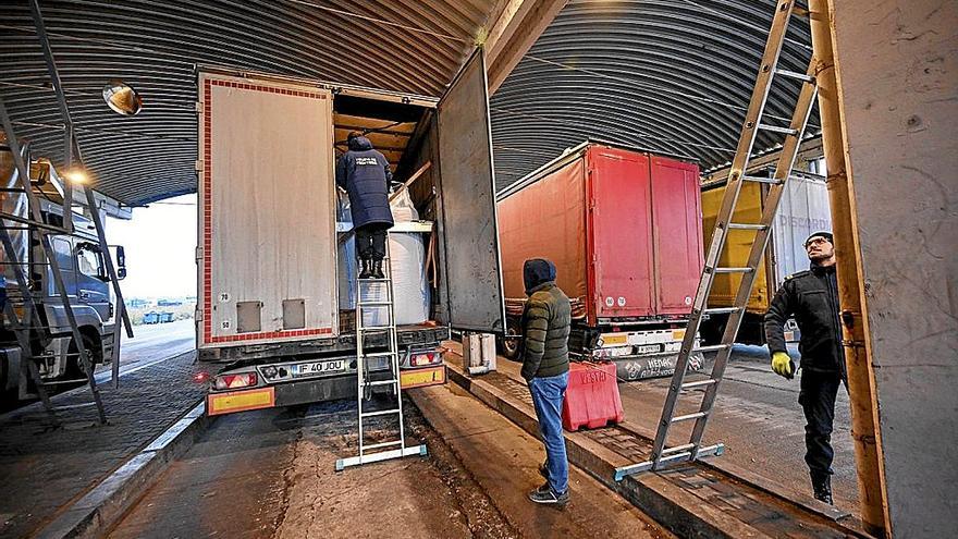 Un agente de aduanas rumano investiga la carga de un camión en la frontera con Bulgaria.