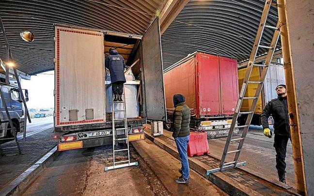 Un agente de aduanas rumano investiga la carga de un camión en la frontera con Bulgaria. Un agente de aduanas rumano investiga la carga de un camión en la frontera con Bulgaria.