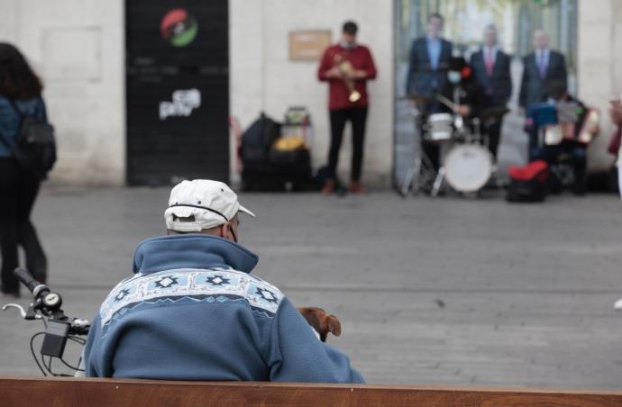 Una persona mayor sentada en un banco